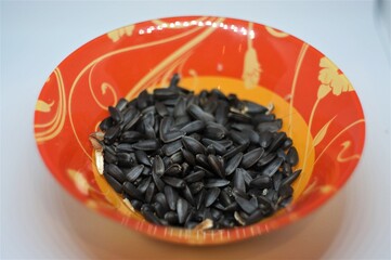 Roasted sunflower seeds in a colored bowl.