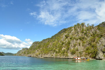 Barcaza de colores con mar y montañas