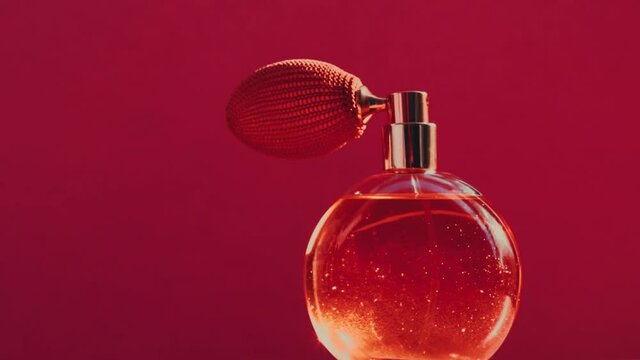Vintage perfume bottle and shining light flares on red background, glamorous fragrance scent as luxury perfumery product for cosmetic and beauty brand, stock footage