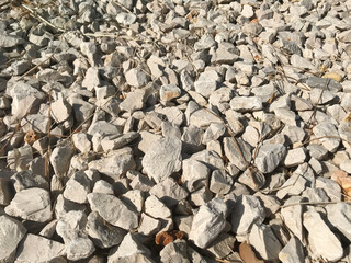 Small rock stone fence grey. Natural stones for construction and exterior design. Grey and white stone background