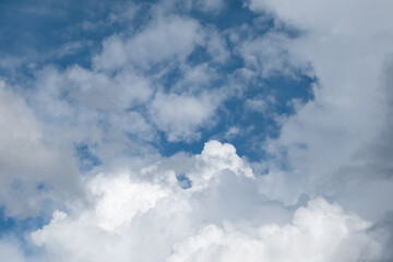 Blue sky and cumulus clouds obscured by storm clouds. White and gray clouds before rain against blue sky background.