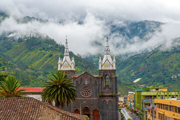 Aerial cityscape of Banos de Agua Santa located in the cloud forest with the bell towers of the...