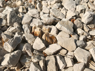 Small rock stone fence grey. Natural stones for construction and exterior design. Grey and white stone background