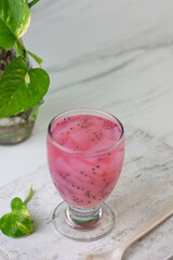 Es Jelly Kelapa Muda or Young coconut ice syrup, Indonesian popular drink, especially for breakfasting during ramadan month. Grainy from the glass. White marble background.