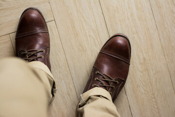 ฺBrown leather shoes with vintage camera on a wooden floor. Brown vintage leather boots aligned selective focus. Men leather shoes 