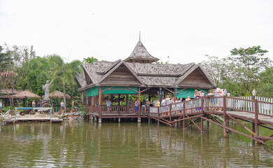 Obraz premium Lake in the park. Tourists drink tea and look at fish in the water