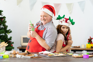 Family cooking is fun. Happy father and cute child daughter having fun preparing baking cookies biscuit cooking together in kitchen with Christmas tree at home. Father and daughter spending together