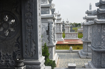 Tombstones and altars of gray stone in an Asian cemetery