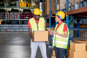 African American warehouse man hold package and discuss together with co-worker in workplace area. Concept of good management system to support working with industrial business.