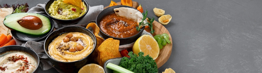 Different kinds of hummus dips with snacks