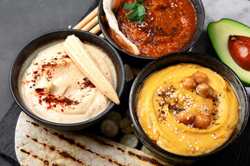 Different kinds of hummus dips with snacks