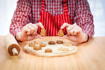 Bakery man holding Christmas gingerbread cookies, fresh homemade cookies after baking, making Xmas ginger bread, preparing bakery, process of baking and cooking at home