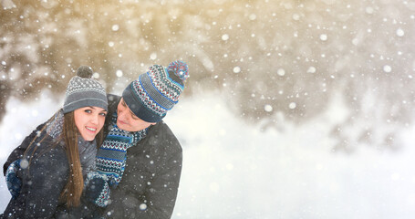 Loving couple in wool hats embracing in the winter forest