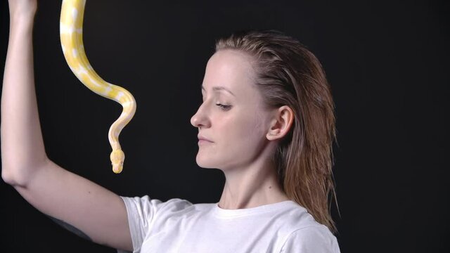 Slow motion video of woman putting up albino python
