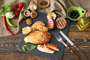 Cooked chicken fillet on wooden table