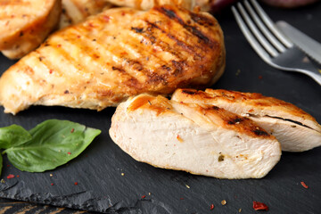Cooked chicken fillet on dark table