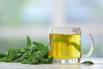Cup of mint tea on blurred background