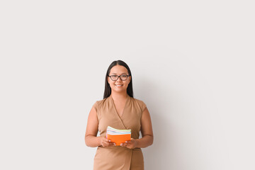 Asian female teacher on light background