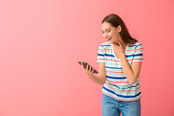 Laughing young woman with e-reader on color background