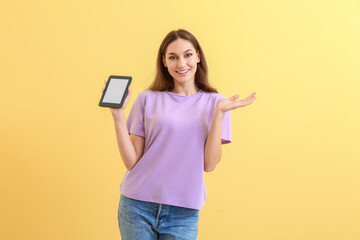 Young woman with e-reader on color background