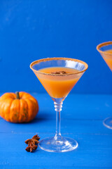 Glass of tasty pumpkin pie martini on color wooden background