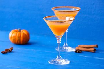 Glasses of tasty pumpkin pie martini on color wooden background
