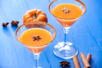 Glasses of tasty pumpkin pie martini on color wooden background