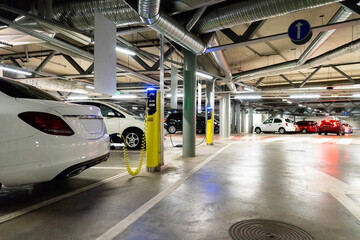 Electric cars are charged from the charging station in the parking lot of the shopping center.	
