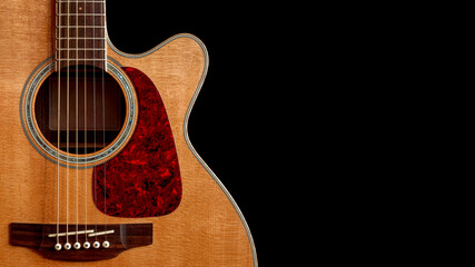 acoustic guitar with top made of spruce wood with cutaway closeup on black background with copy space