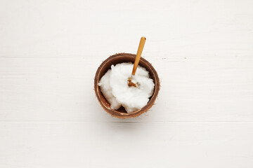 Shell with coconut oil on white wooden background