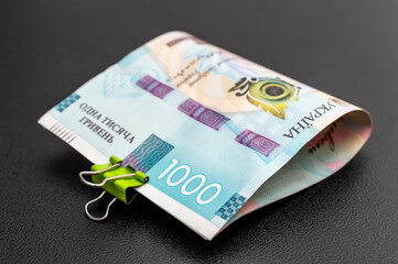 Folded new ukrainian one thousand hryvnia banknotes on black.