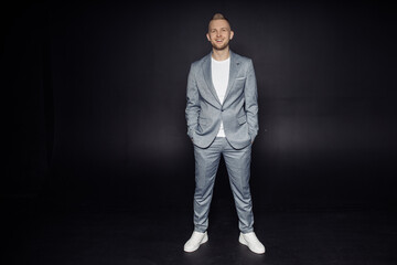 Full length body size photo of man wearing grey classy suit smiling cheerful isolated on black...