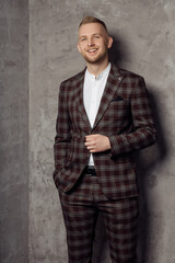 Obraz premium Photo portrait of businessman wearing checkered burgundy suit confident smiling standing on grey background