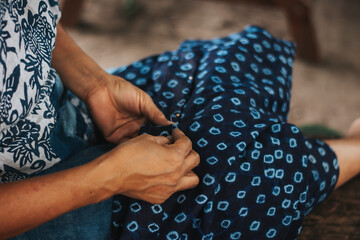 An artist of long experience is sewing the beautiful natural dye indigo.