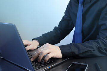 an asian business man in black shirt is working on a personal laptop computer on the working desk during making decision plan about business investment of his company in covid19 pandamic crisis