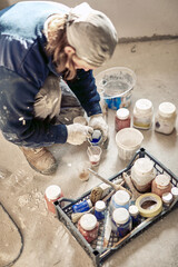 Worker mixing paint during home renovation.