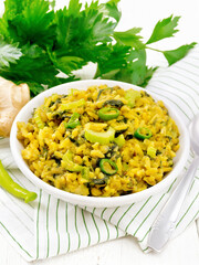 Kitchari with celery in bowl on white board