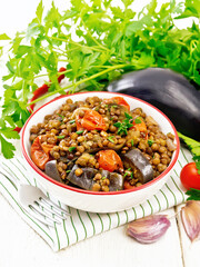Lentils with eggplant in bowl on towel