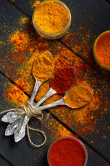 spices on a wooden background chilli, paprika, curry