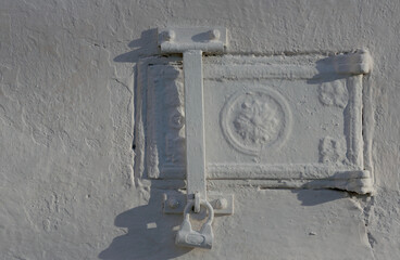 A locked hatch on a white painted wall