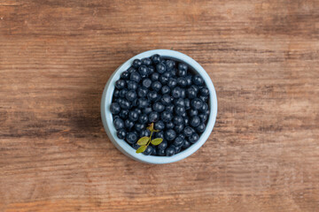 Tasty blueberries on wooden board background, top view. Healthy eating
