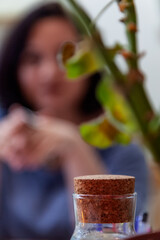 Blurry silhouette of a Brunette woman sitting at a table with her head in her hands. The concept of loneliness, despair