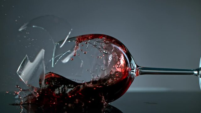 Breaking Glass with Red Wine on Grey Background at 1000 fps.