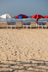 Goa, India- 11 November 2020, Early Morning beach with sun beds and colorful umbrellas on the baga beach in Goa India