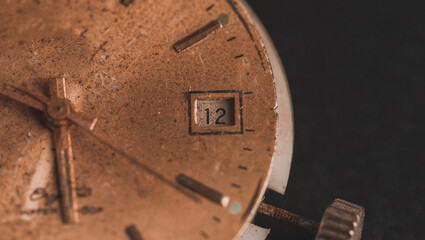 Vintage wall clock on a dark background. Selective focus. Vintage light toning. Grunge style backdrop