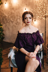 beautiful young girl for christmas in a happy mood against the background of a christmas tree and lights indoors