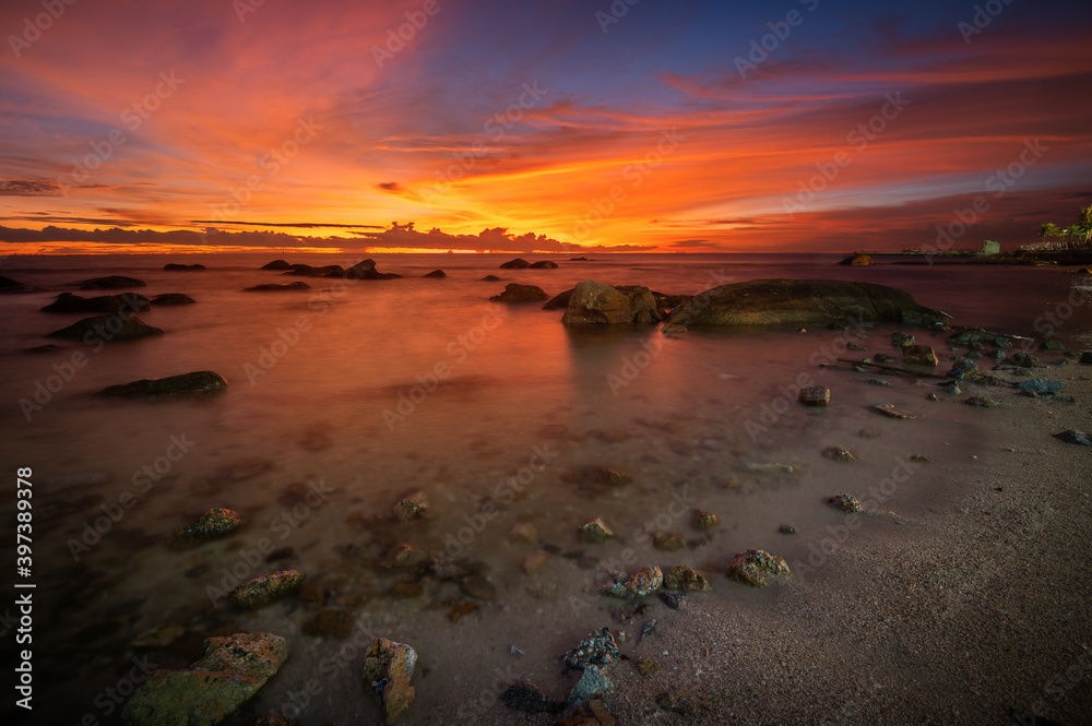 Wall mural The rock on the sea with sunset sky