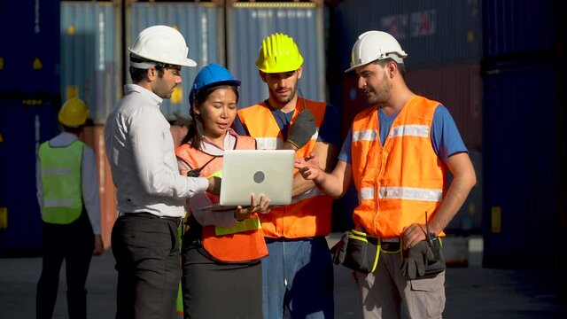 Foreman and secretary using laptop computer  meeting with worker to checking  control loading Containers box at warehouse logistic in Cargo freight ship for import export in harbor. shipping in docks.