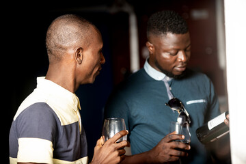 two handsome young people holding a glass of red wine