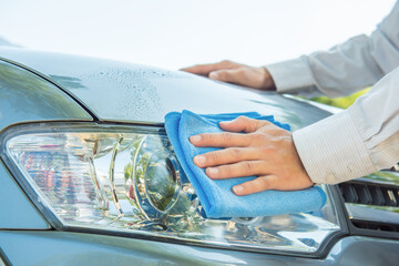 Worker use clean cloth to wipe the car after washing in the car wash shop